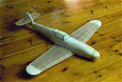 Alarmingly primitive Bf 109 F prototype in mixed foam/balsa, built to 1/12 scale.
Although the artistic appearance of this my first foam job ever is nothing to be proud of, the aerodynamic properties are not bad at all. Wingspan 83 cm, Clark Y-ish aerofoil.
Total weight 128 gram (including 34 gram nose ballast).
Glides at 4.5 m/s. Rate of descent is about 0.75 m/s.